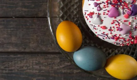 Easter cake in a transparent dish, around painted eggs in the colors of the f Stock Photos