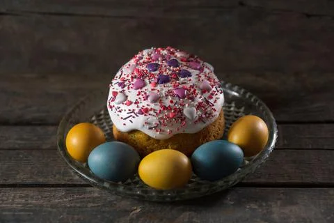Easter cake in a transparent dish, in the foreground are painted eggs in the  Stock Photos