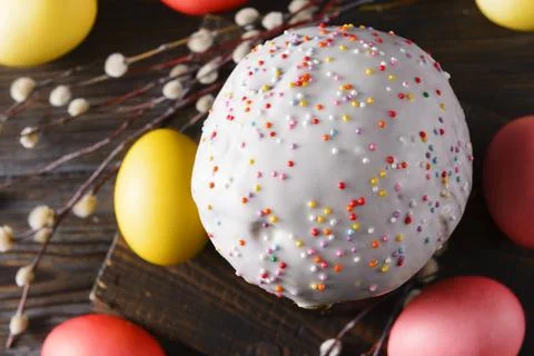 Easter cake with willow twigs and yellow and pink colored eggs on a dark back Stock Photos