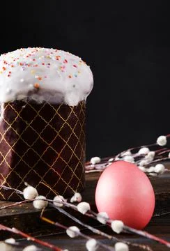 Easter cake with willow twigs and  pink colored eggs on a dark background Stock Photos