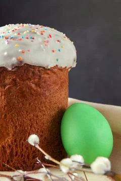 Easter cake with willow twigs and 1 green egg on dark background Foto stock