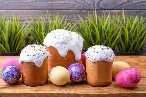 Easter cakes and Easter colored eggs on a wooden background. Stock Photos