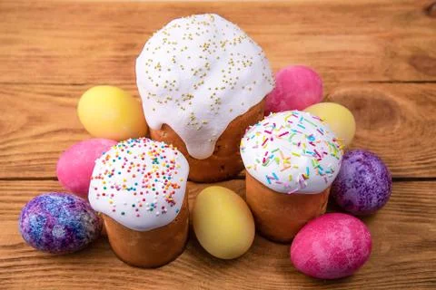 Easter cakes and Easter colored eggs on a wooden background. Stock Photos