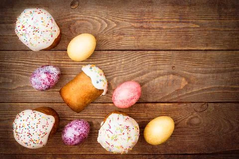 Easter cakes and Easter colored eggs on a wooden background. Stock Photos