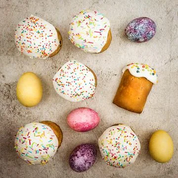 Easter cakes and Easter colored eggs on a beautiful textured background. Stock Photos