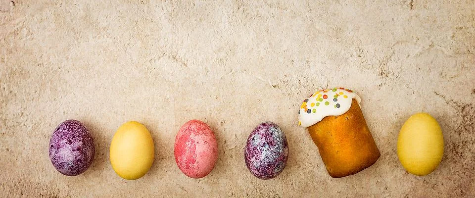 Easter cakes and Easter colored eggs on a beautiful textured background. Stock Photos
