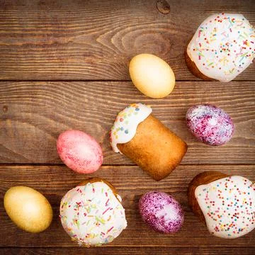 Easter cakes and Easter colored eggs on a wooden background. Stock Photos
