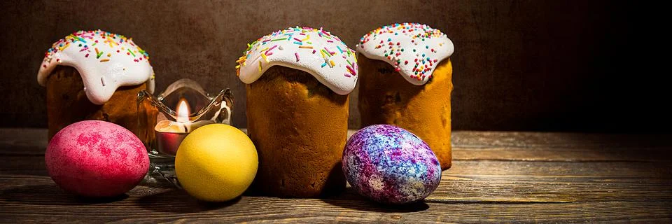 Easter cakes and Easter colored eggs on a dark background. Stock Photos