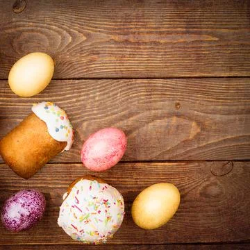 Easter cakes and Easter colored eggs on a wooden background. Stock Photos