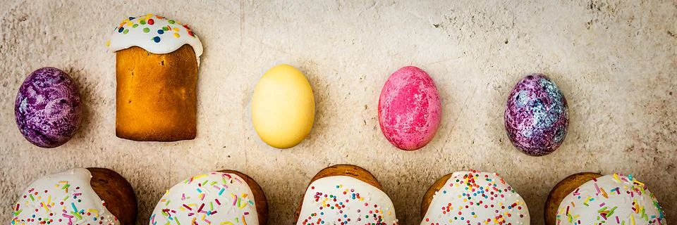 Easter cakes and Easter colored eggs on a beautiful textured background. Stock Photos