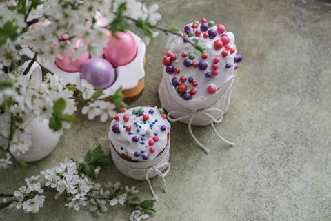 Easter cakes, painted eggs and vase of blossoming cherry branches Stock Photos