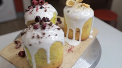 Easter cakes with white icing, decorated with various berries and an orange Stock Footage 128567033