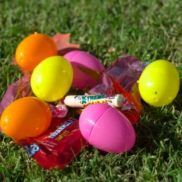 Easter candies with plastic eggs on the grass in spring Stock Photos