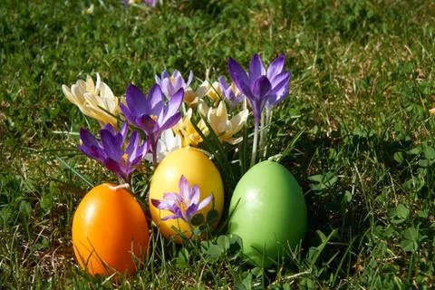 Easter candle in egg form between spring flowers Stock Photos