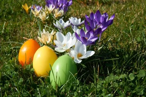 Easter candle in egg form between spring flowers Stock Photos