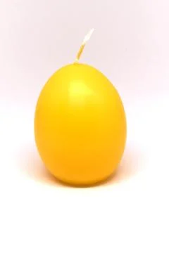 Easter candle in egg form on a white background Stock Photos