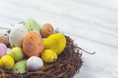 Easter  candy eggs in different colors in nest Easter holiday candy concept. Stock Photos