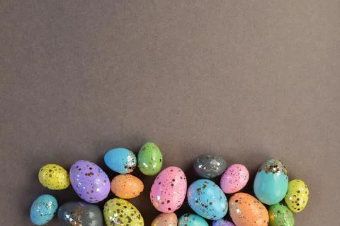 Easter card with bed-colored eggs and sequins on a gray background. Stock Photos