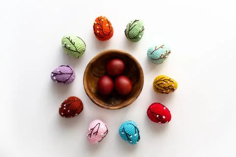 Easter card with colored crocheted eggs and red Easter eggs in a wooden plate Foto stock