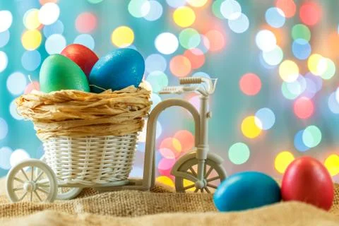 Easter card, colored eggs in the nest. Toy Bicycle with a cart. happy Easter. 스톡 사진