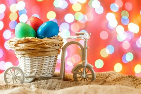 Easter card, colored eggs in the nest. Toy Bicycle with a cart. happy Easter. Stock Photos