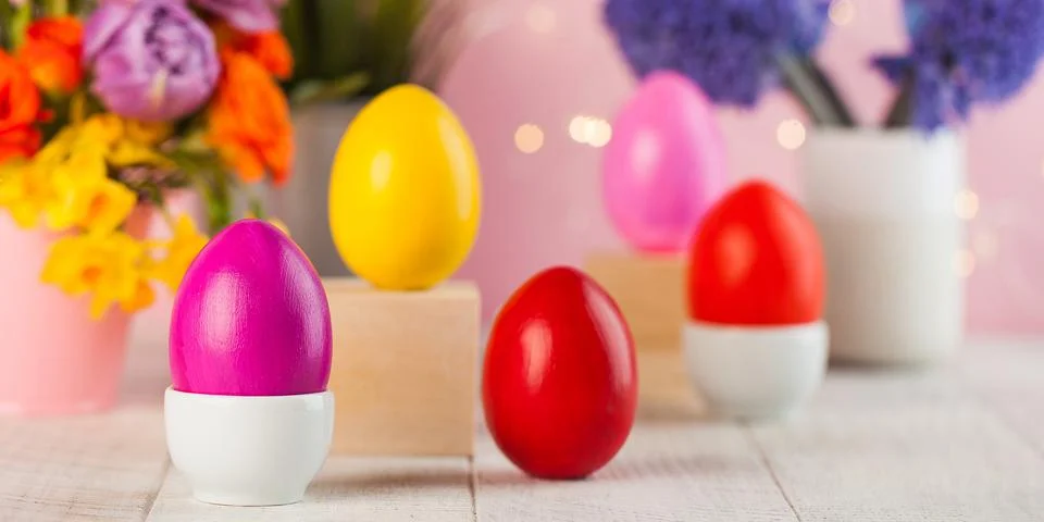 Easter card. Colorful Easter eggs on the background of a bouquet of flowers. Stock Photos