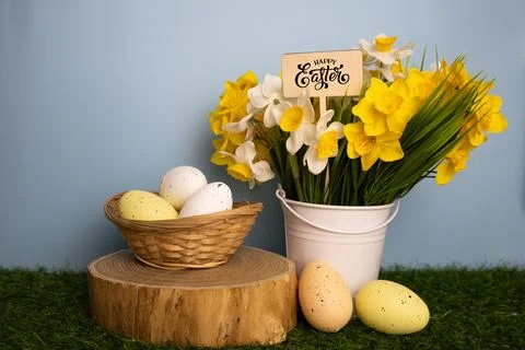 Easter card featuring yellow daffodil flowers in a bucket and colorful eggs i Stock Photos