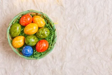 Easter card. Flat lay composition with easter eggs in a basket on white Stock Photos