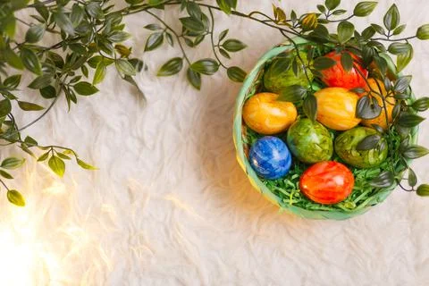 Easter card. Flat lay composition with easter eggs in a basket on white Stock Photos