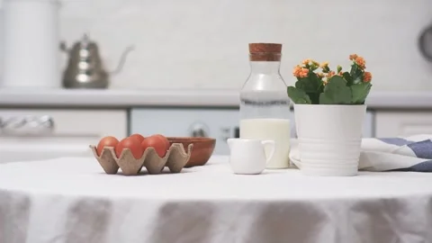Easter celebration concept. Easter eggs, bottle of milk, flowers in white pot on Stock Footage 268743175