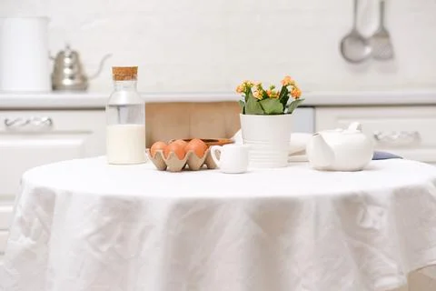Easter celebration concept. Easter eggs, bottle of milk, flowers in white pot Stock Photos