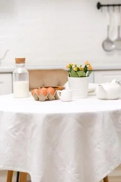 Easter celebration concept. Easter eggs, bottle of milk, flowers in white pot on Stock Photos