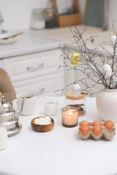 Easter celebration concept. Easter eggs, glass of tea, branches with colorful Stock Photos