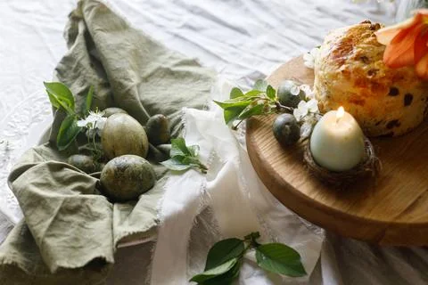 Easter celebration. Stylish green easter eggs, easter bread, candle and che.. Stock Photos