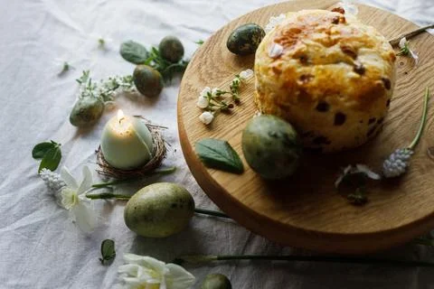 Easter celebration. Stylish green easter eggs, easter bread, candle and che.. Stock Photos