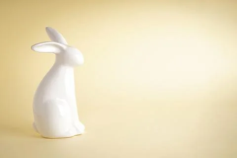 Easter ceramic bunny on yellow background, place for text. Stock Photos