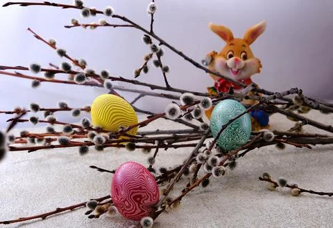 Easter. A cheerful Easter bunny with a bell and painted eggs on the backgro.. Stock Photos