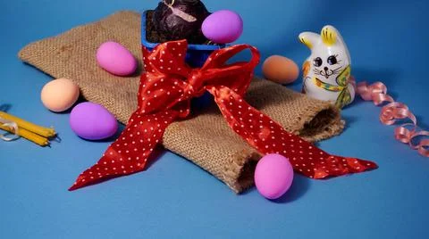 Easter with chicken eggs of different colors with a rabbit figurine on a linen b 스톡 사진