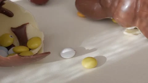 Easter Chocolate Egg Bursting with Colorful Candies in Sunlit Scene Stock Footage 332943534