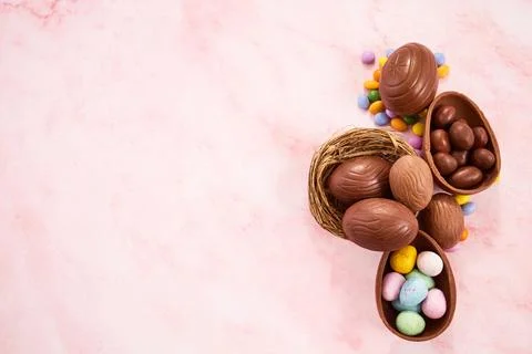 Easter chocolate eggs and sweets on pink background Foto stock