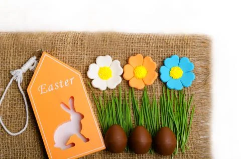 Easter chocolate eggs on a background of green grass and burlap. Foto stock