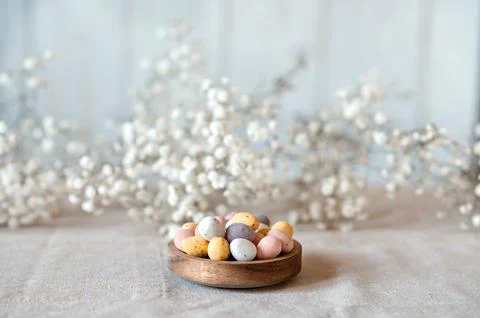 Easter chocolate Multi-Colored eggs in pastel colors in wooden bowl with Stock Photos