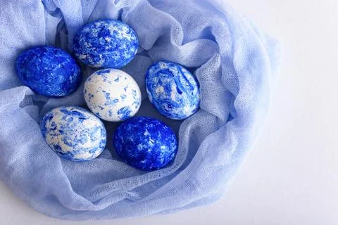 Easter classic blue eggs in soft blue napkin on white background Stock Photos