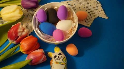 Easter with colored chicken eggs in a white plate with a porcelain rabbit figuri Foto stock