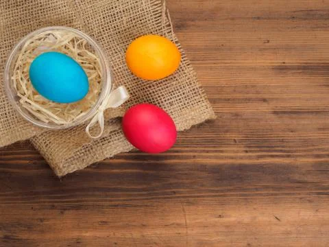 Easter colored egg on burlap and old wooden texture table. Mock up for your Fotos de archivo