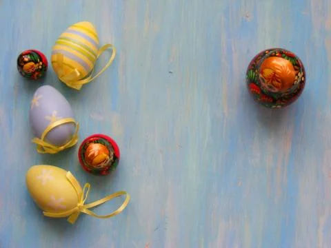 Easter colored eggs and dolls matrioshka (dolls matreshka) on blue wooden bac Stock Photos