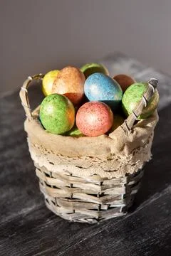 Easter colored eggs in a basket on dark wooden background. Foto stock