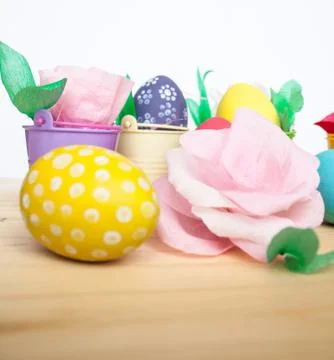 Easter colored eggs in colorful buckets and paper flowers Stock Photos