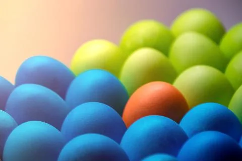 Easter colored eggs in the glare of light multi color close up one stands out Stock Photos