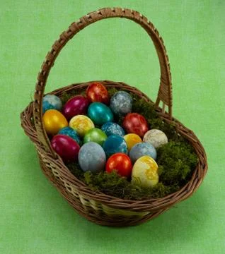 Easter, colored painted eggs in a wicker basket with moss Stockfoto's